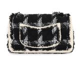 the black and white checkered purse is on display against a white background