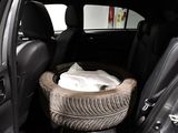 a tire in the back of a car with a bag in it