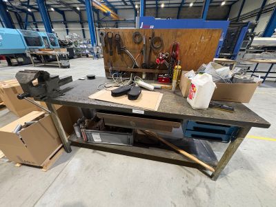 un établi dans un entrepôt, sur lequel se trouvent de nombreux outils