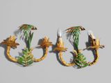 two wall sconces with palm trees and birds on them