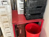 a red trash can sitting next to a stack of crates
