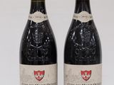 two bottles of red wine sitting next to each other on a table