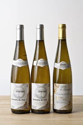 trois bouteilles de vin posées sur une table en bois