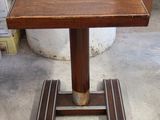 une petite table en bois avec un piètement en métal, posée sur un sol en béton