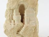 a stone sculpture of a castle on a white surface