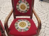 two red chairs with floral designs on them on the sidewalk