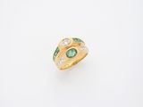 un gros plan sur une bague en or sertie d'une émeraude et de diamants