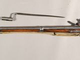 an old rifle is laying on a white surface next to a key