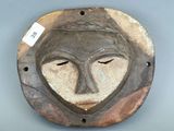 une image représentant un masque en bois accroché au mur