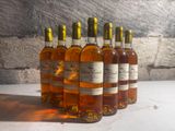 six bottles of wine are lined up in a row on a table