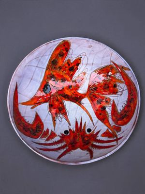 une assiette sur laquelle est représentée une femme et deux crabes