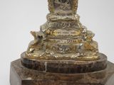 a statue of a clock on a marble pedestal