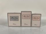 three boxes of perfume sitting on top of a white table