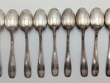 six spoons are lined up in a row on a white surface