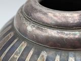 a close up of a vase on a white surface