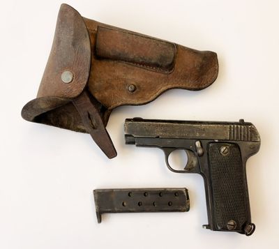 un pistolet et un étui posés sur une surface blanche