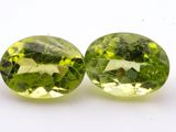 pair of green tourmaline gems on a white background