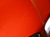a close up of a red car with a light on it