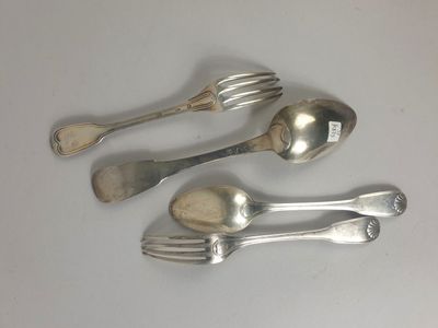 trois cuillères en argent et deux fourchettes en argent posées sur un plateau blanc