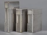two silver lighters sitting next to each other on a table