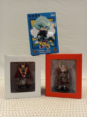 two boxes of anime figurines are sitting next to each other