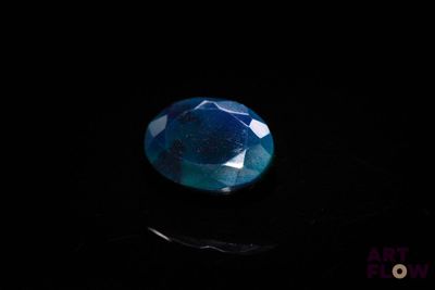 a close up of a blue diamond on a black surface