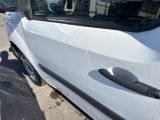 a white van parked in a parking lot with a person standing next to it