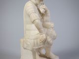 statue représentant un homme assis sur un tabouret, tenant un vase