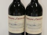 two bottles of wine sitting on top of a table next to each other