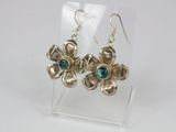 a pair of silver earrings with green stones on them