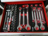 de nombreux outils dans une boîte à outils rouge posée par terre