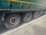 a green semi truck that is parked in a parking lot