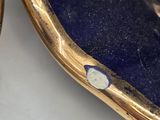 a gold plate with a blue and white design on it