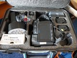 une mallette rigide contenant du matériel électronique, posée par terre