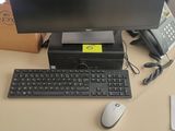 un bureau sur lequel se trouvent un ordinateur, un clavier, une souris et un téléphone