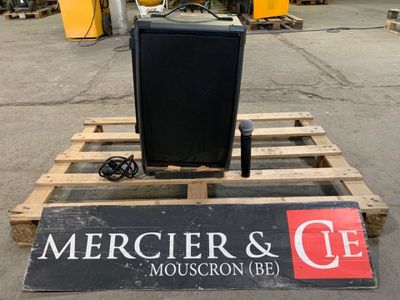 a television sitting on top of a pallet in the middle of a parking lot