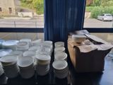 many plates and cups sitting on a table in front of a window