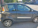 a small grey car parked on the side of the road