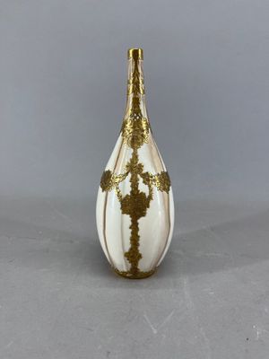 un vase blanc et doré orné d'une croix