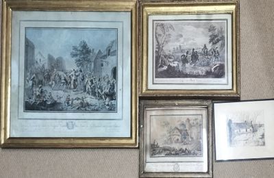 de nombreux tableaux encadrés accrochés au mur d'une pièce