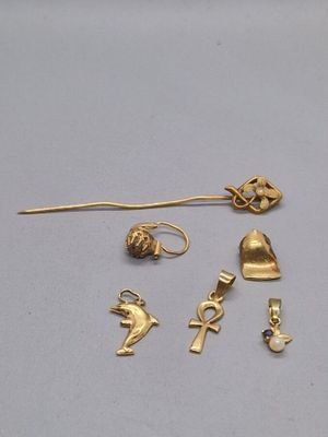 Plusieurs bijoux en or sont exposés sur un fond blanc