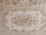 an antique rug with a floral design on a beige background