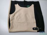 the top of a black and beige shirt with a belt