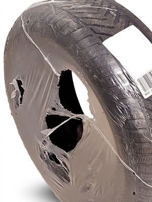 un pneu emballé dans du plastique et sur lequel est collé un autocollant