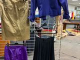 a rack with a variety of skirts and jackets on it