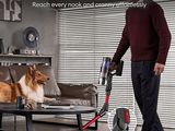 a man that is standing next to a dog with a vacuum