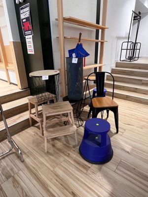 Plusieurs chaises et tabourets sont exposés dans une pièce