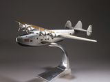 une maquette d'avion en argent posée sur un socle métallique