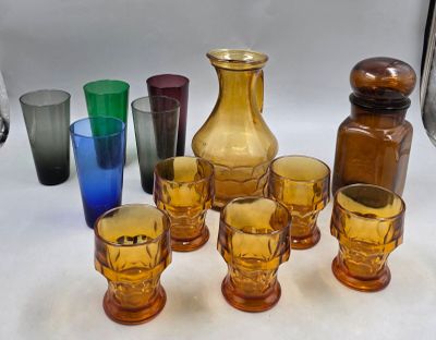 des bouteilles et des verres sont alignés sur une table à fond blanc