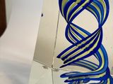 a glass sculpture of a blue and yellow spiral design